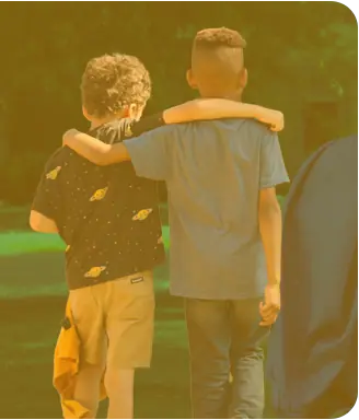 Two boys walking with their arms around each other’s shoulders at the Y.
