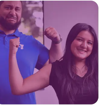 A Y staff member and a teenager flexing their arms and laughing together.