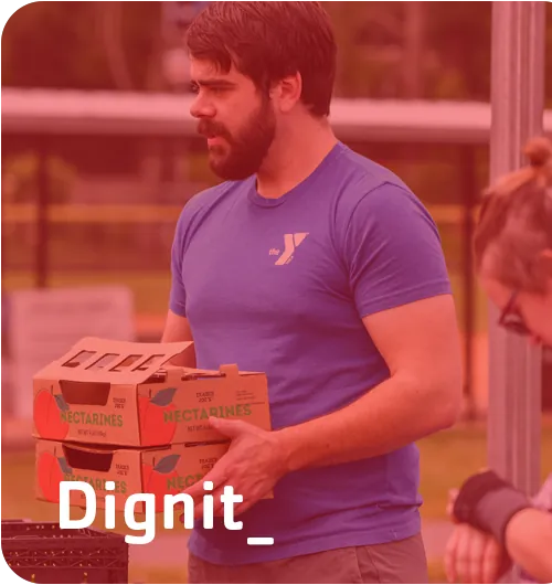 Dignity — a Y staff member carrying boxes of food for the community.