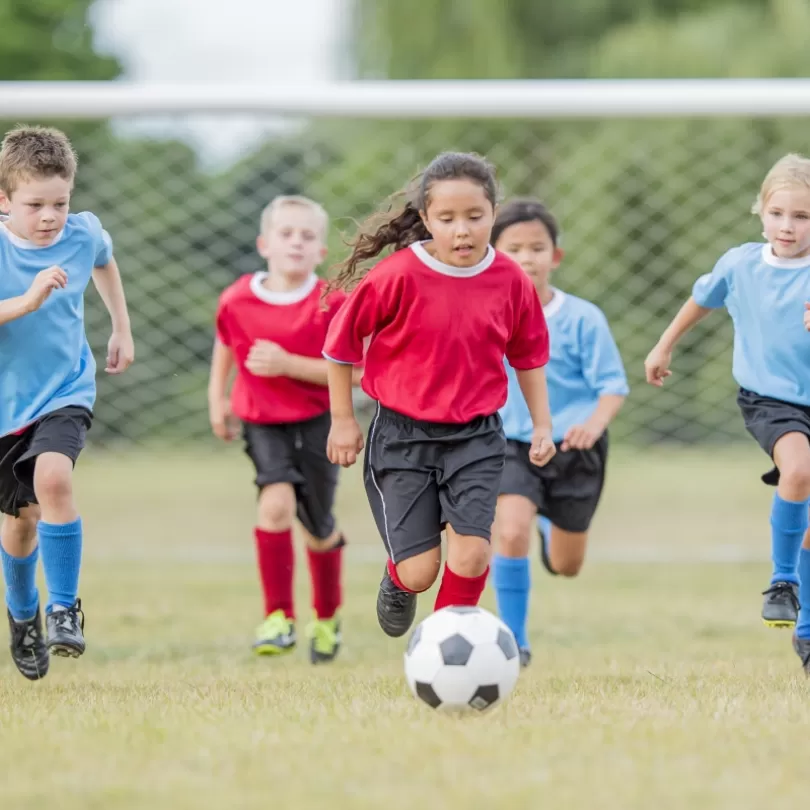 Youth soccer teams chasing ball