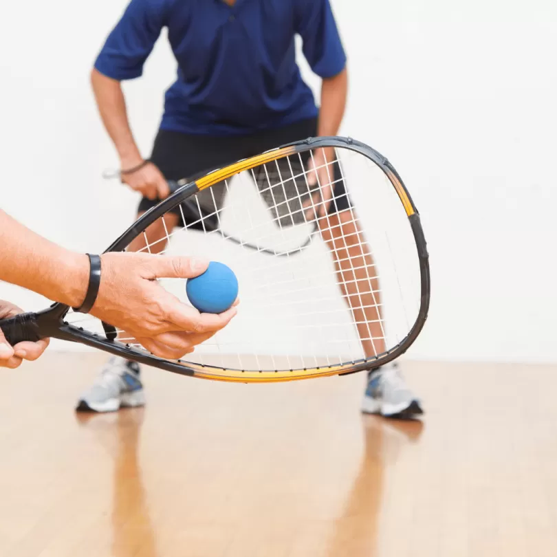 Two adults playing racquetball.