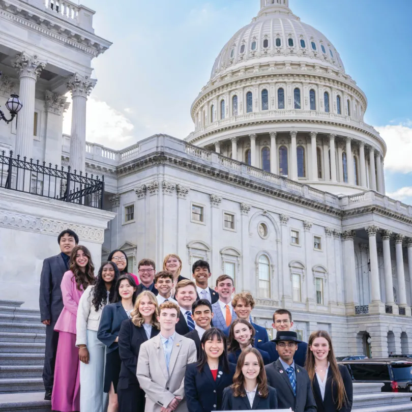A group of teens in Youth Government stand in front of the Capitol Building.