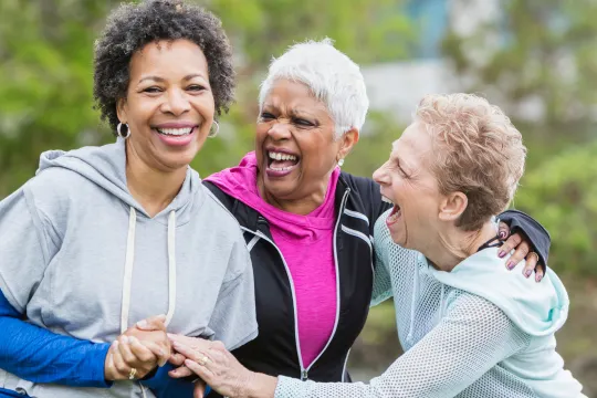 A group of older women laugh together.