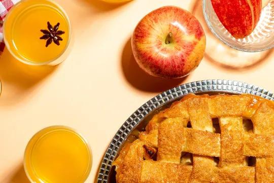 An above angle of a table full of different apple foods and drinks.