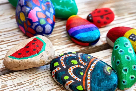 Multiple painted rocks on a table.