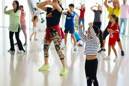 A family dances together in a group dance class.