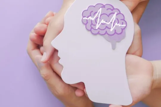 Two hands hold a purple-colored depiction of a brain for Stroke Prevention and Awareness.