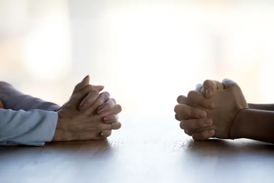 Two pairs of hands facing each other during conversation