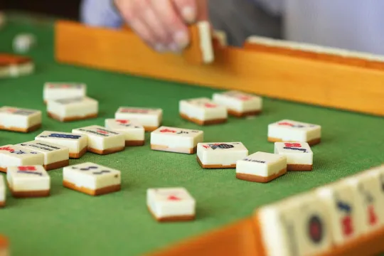 A close-up of someone playing a game of mahjong.