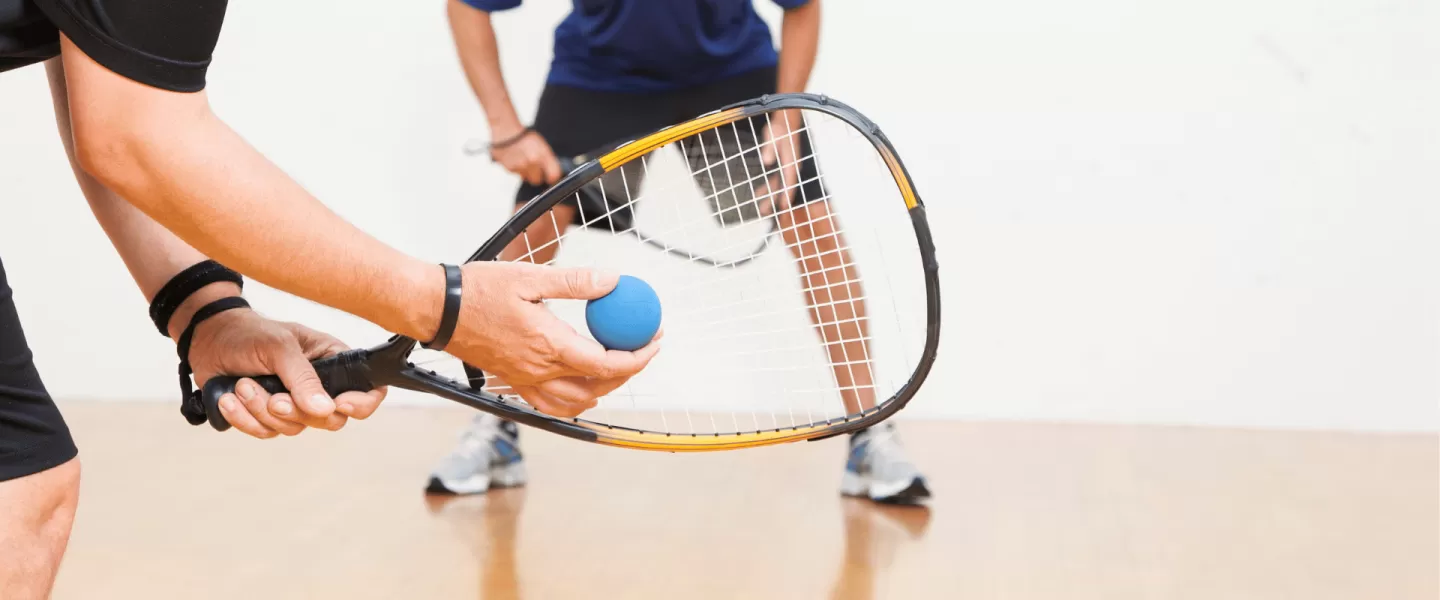 Two adults playing racquetball.