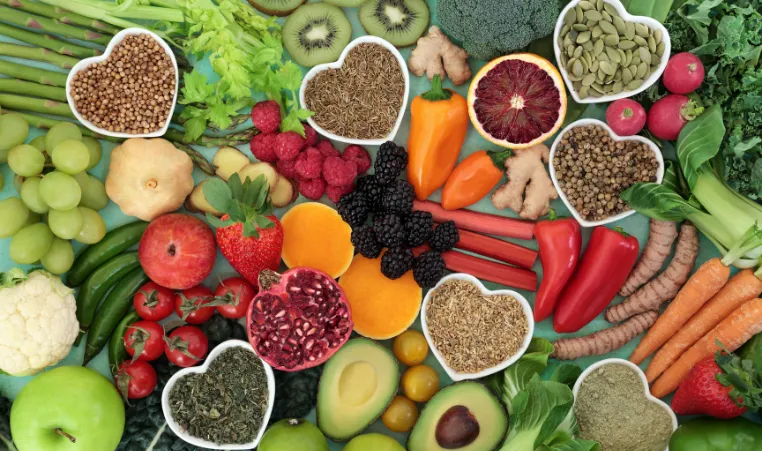An above angle of a variety of healthy foods like fruits, vegetables, and nuts.
