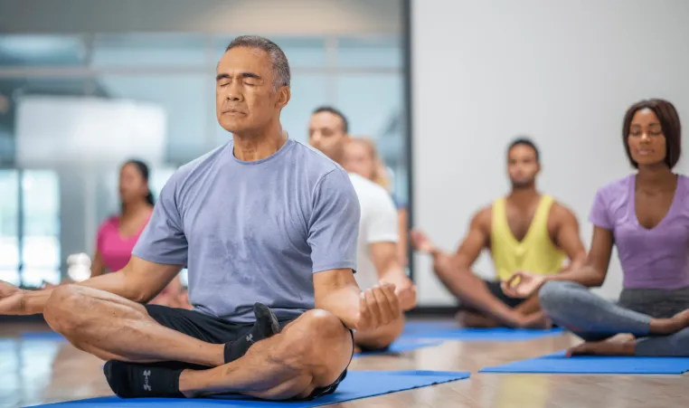 Elderly man in group yoga class.