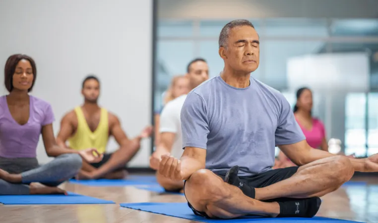 Elderly man in group yoga class.