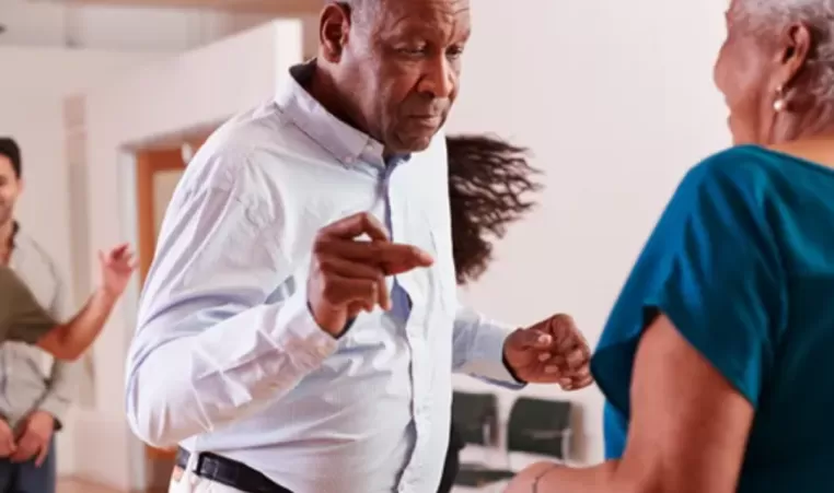 An elderly couple dances together during dance class.