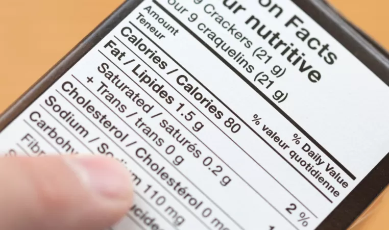 A finger points to a food nutrition label.