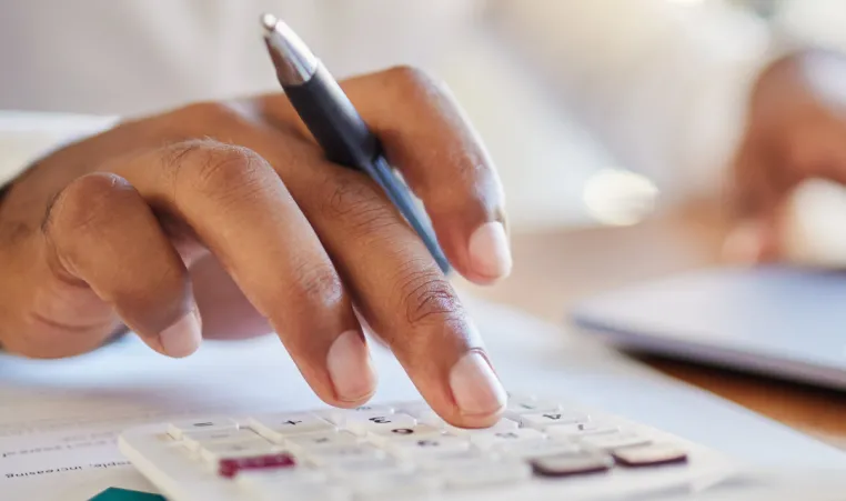 A close up of someone using a calculator to manage finances.