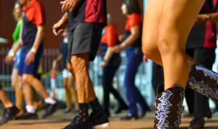 A close up of people dancing in a line dancing class.
