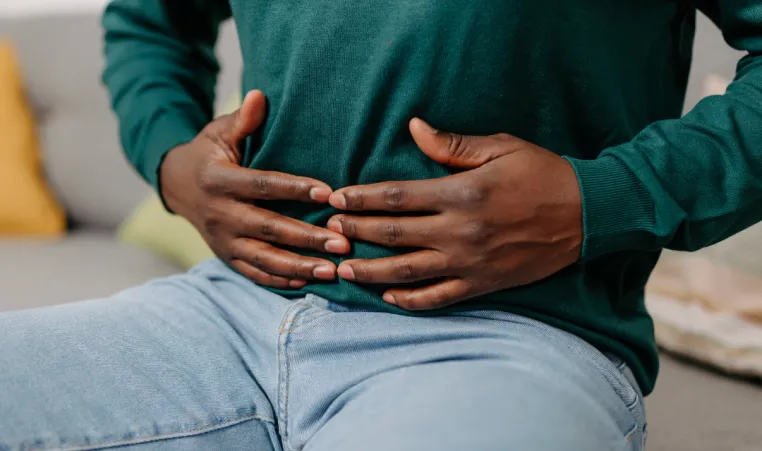 A man places his hands over his stomach.