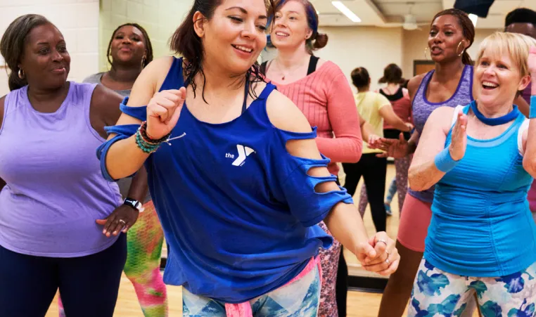 A dance instructor leads a group during a group exercise dance class.