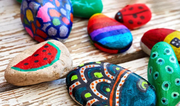 Multiple painted rocks on a table.
