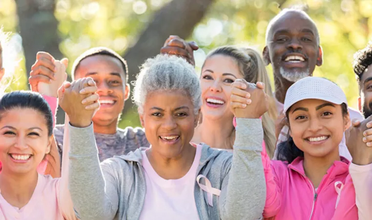 A group of people holding hands for Breast Cancer Awareness walk.