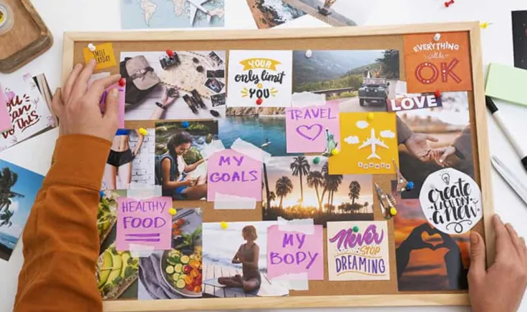 Overhead view of a person working on a vision board.