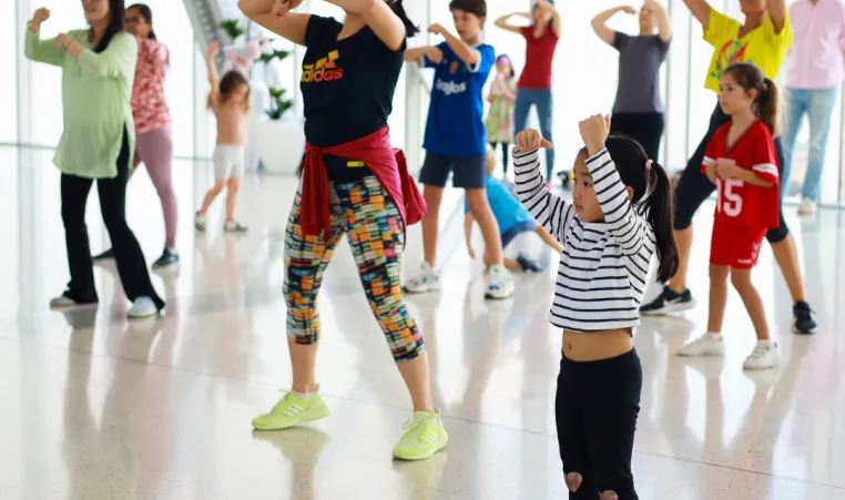 A family dances together in a group dance class.