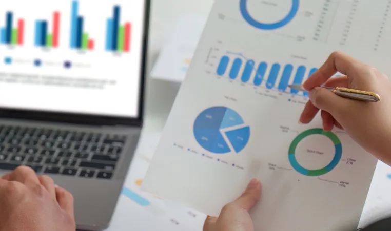 Two people use graphs and bank information to plan finances.