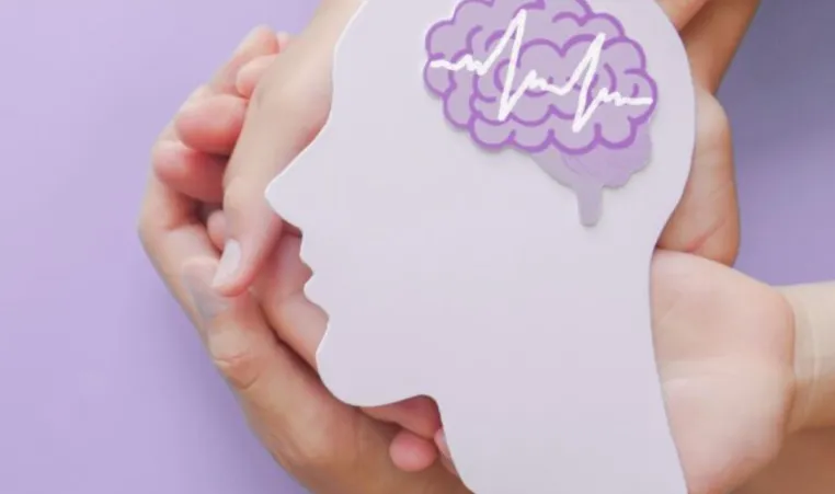 Two hands hold a purple-colored depiction of a brain for Stroke Prevention and Awareness.