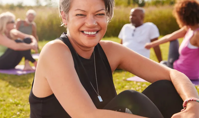 A group of people do wellness activities outside.