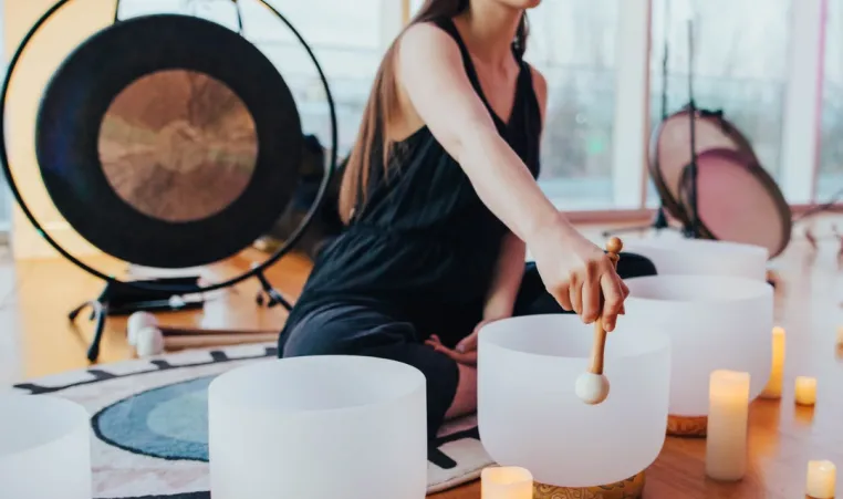 A woman with singing bowls and a gong leading a Sound Bath Experience.