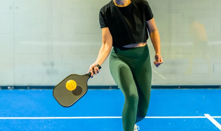 Woman playing pickleball indoors during workshop
