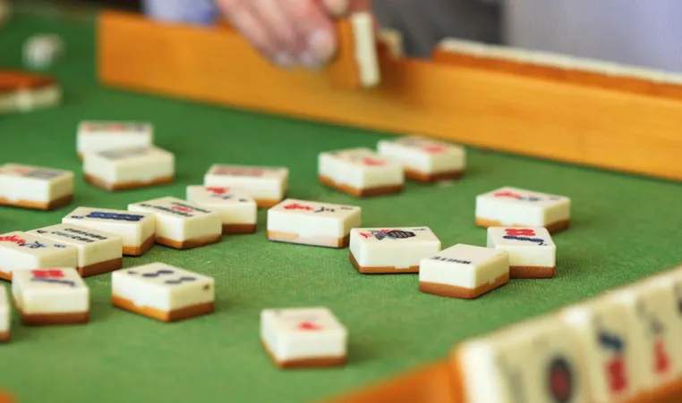 A close-up of someone playing a game of mahjong.
