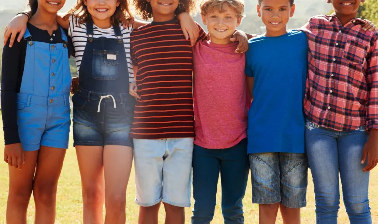 Group of middle school pre-teens smiling together outside